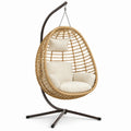 Sillón colgante de ratán con cojines beige y estructura de acero